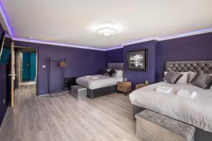 a hotel room with two beds and purple walls at Town View Apartment by Sasco in Blackpool