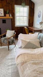 a living room with two beds and a table at Retro Ypsilanti Cottage - Peloton & Vintage Vibes in Ypsilanti