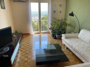 een woonkamer met een witte bank en een glazen tafel bij Lovely apartment with fabulous view in Koper