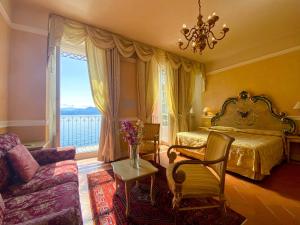 ein Schlafzimmer mit einem Bett, einem Sofa und einem Fenster in der Unterkunft Hotel Cannero in Cannero Riviera