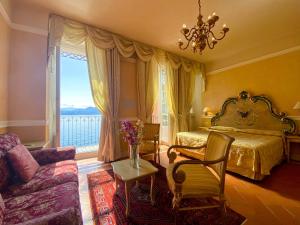 1 dormitorio con cama, sofá y ventana en Hotel Cannero en Cannero Riviera