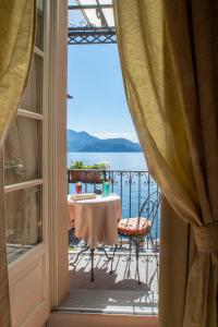 uma varanda com uma mesa e vista para a água em Hotel Cannero em Cannero Riviera