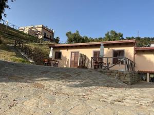 a house with a stone patio in front of it at Mama Lina in Patti