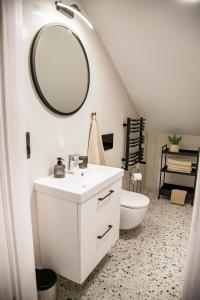 a bathroom with a white sink and a mirror at Apartamenty z tarasami - Moja Gdynia in Gdynia