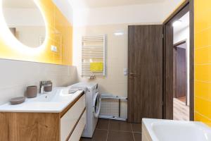 a bathroom with a sink and a washing machine at Modern & Newly built apartment with private garage in Budapest +30 photos