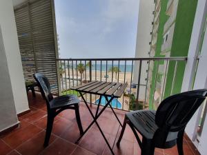 een balkon met een tafel en stoelen en het strand bij SingularStays Cullera IV in Cullera