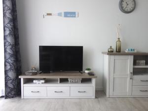 a living room with a tv on a white entertainment center at Studio Verdemar Nexo in Puck