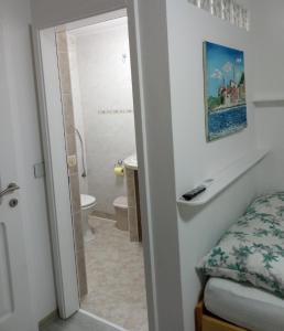 a bathroom with a bed and a bathroom with a toilet at Apartma na vasi in Sečovlje