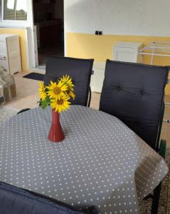 a vase with yellow flowers sitting on a table at Apartma na vasi in Sečovlje