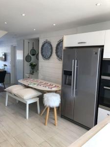 a kitchen with a refrigerator and a table with a stool at Étoile des Monje in Cucq