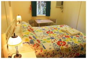 a bedroom with a bed and a lamp at Coral Lodge Bed and Breakfast Inn in Townsville