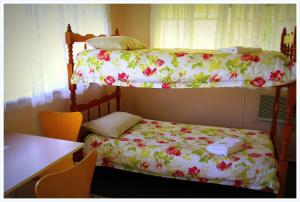 a small bedroom with a bed and a desk at Coral Lodge Bed and Breakfast Inn in Townsville