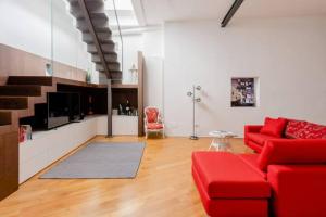 ein Wohnzimmer mit einem roten Sofa und einer Küche in der Unterkunft Bijoux Luxury Apartment in Old Town in Bari