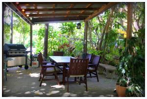 een patio met een tafel en stoelen en een grill bij Coral Lodge Bed and Breakfast Inn in Townsville