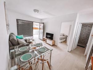 a living room with a table and a couch at Dahlia Apartment DunaSol in Corralejo