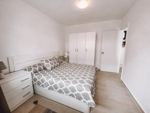una camera bianca con letto e armadietto bianco di Dahlia Apartment DunaSol a Corralejo