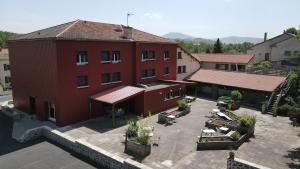 einen Luftblick auf ein rotes Gebäude mit einer Terrasse in der Unterkunft Hôtel Les Rives D'Allier in Reilhac