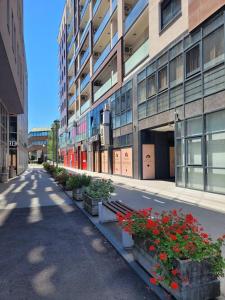 an empty street in front of a building with flowers at Apartmani Kastel in Banja Luka