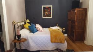 a bedroom with a large bed with blue pillows at Montagu Manor in Montagu