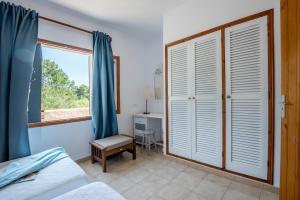 a bedroom with a bed and a window and a desk at Aguamar - Emar Hotels in Playa Migjorn