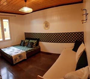 ein Wohnzimmer mit einem Sofa und einem Bett in der Unterkunft lilie97418 in La Plaine des Cafres