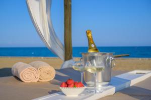 a table with a bottle of champagne and a bowl of strawberries at Pareus Beach Resort in Caorle