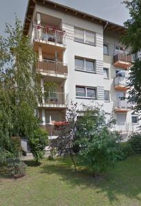 een appartementencomplex met balkons en bomen in een tuin bij Bellis Apartment in Szczecin
