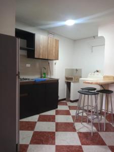 uma cozinha com piso xadrez vermelho e branco em ESTADIO APARTA HOTEL 201 em Medellín