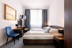 a hotel room with a large bed and a desk at Hotel i Restauracja Nad Jeziorem in Człuchów +42 photos