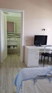 um quarto com uma cama e uma secretária com uma televisão em Adriatic East View Apartment em Durrës