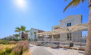a resort with chairs and umbrellas on the beach at Pareus Beach Resort in Caorle