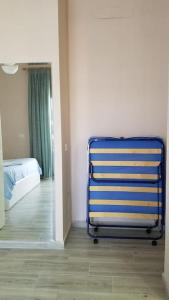 uma cadeira azul numa sala com um quarto em Adriatic East View Apartment em Durrës