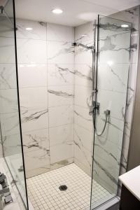 a bathroom with a shower with marble tiles at Saint-Sulpice Montréal in Montréal