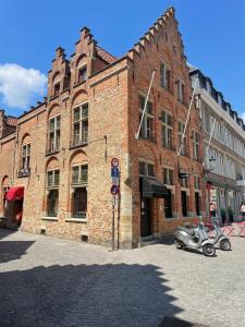 a brick building with a motorcycle parked in front of it at Hotel Salvators in Bruges