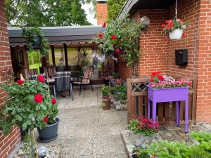 un jardín con flores y plantas en un edificio de ladrillo en Ingrid Merkle aus Neckarsulm en Karby