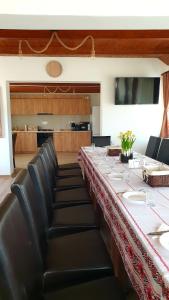 uma mesa longa num quarto com cadeiras de couro preto em Vatra Strabunilor em Moigrad