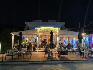 a restaurant with people sitting at tables at night at Galini Hotel Bed and Breakfast in Skala