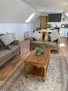 a living room with two couches and a coffee table at The Art Loft, Crieff: Town Centre Apartment in Crieff