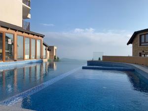 a swimming pool with blue water in front of a building at Milmari Premier40 in Kopaonik