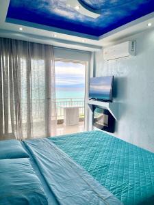 卡尼奧提的住宿－CHANIOTH LUXURY SUITES BY MAKHOME，一间卧室设有一张床、一台电视和一个窗口。