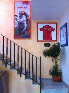 Pensione Villa Ida في تيرمولي: درج فيه صورتين ودراجة نارية على الحائط
