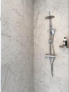 a shower in a bathroom with white marble walls at Suite city center in quiet street & airco in Antwerp