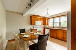 a kitchen with a wooden table and chairs and a dining room at The Mont-Tremblant Hideaway by InstantSuites in Mont-Tremblant