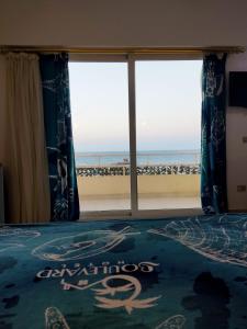 a bed in front of a large window at Boulevard Apartment Hotel in Hurghada