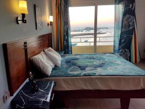 a bed sitting under a window next to a large window at Boulevard Apartment Hotel in Hurghada