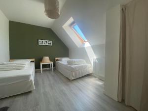 - une chambre mansardée avec 2 lits et une fenêtre dans l'établissement Maison calme familiale proche plages, à Erquy