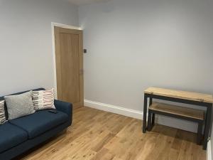 a living room with a blue couch and a table at Great 2 bedroom flat in Plymouth
