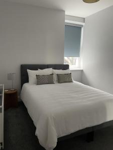 1 dormitorio con 1 cama blanca grande y ventana en Great 2 bedroom flat, en Plymouth