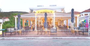 斯卡拉Galini Hotel Bed and Breakfast的有桌椅和遮阳伞的餐厅