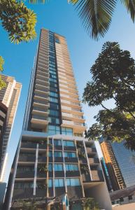 a tall building with trees in front of it at Oaks Brisbane on Margaret Suites in Brisbane